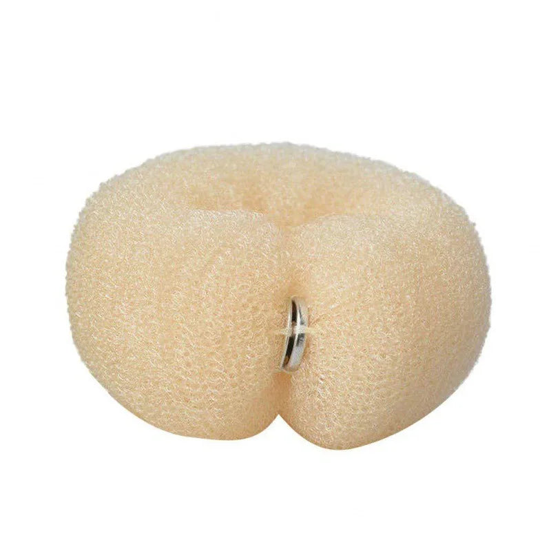 A light beige gauze hair bun tool with a silver ring, used for styling curly hair.
