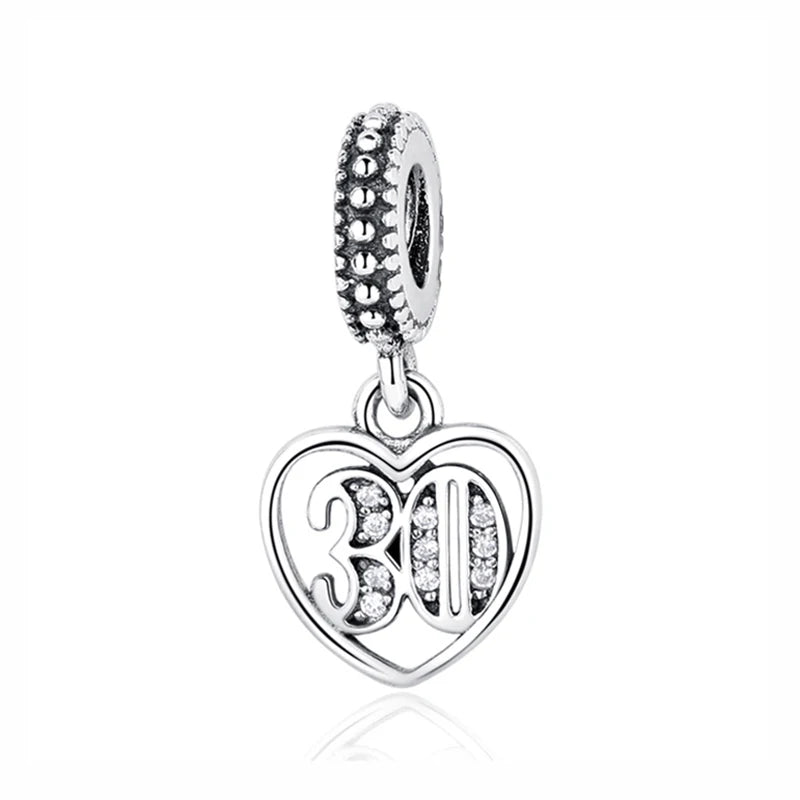 A silver family tree charm necklace featuring a heart pendant and a textured bail.