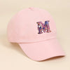A pink baseball cap featuring a purple unicorn letter M embroidered on the front.