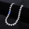 A delicate necklace featuring sparkling heart-shaped rhinestones and diamonds displayed on a black surface.