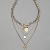 A multilayered gold and silver chain necklace featuring a star eye pendant.