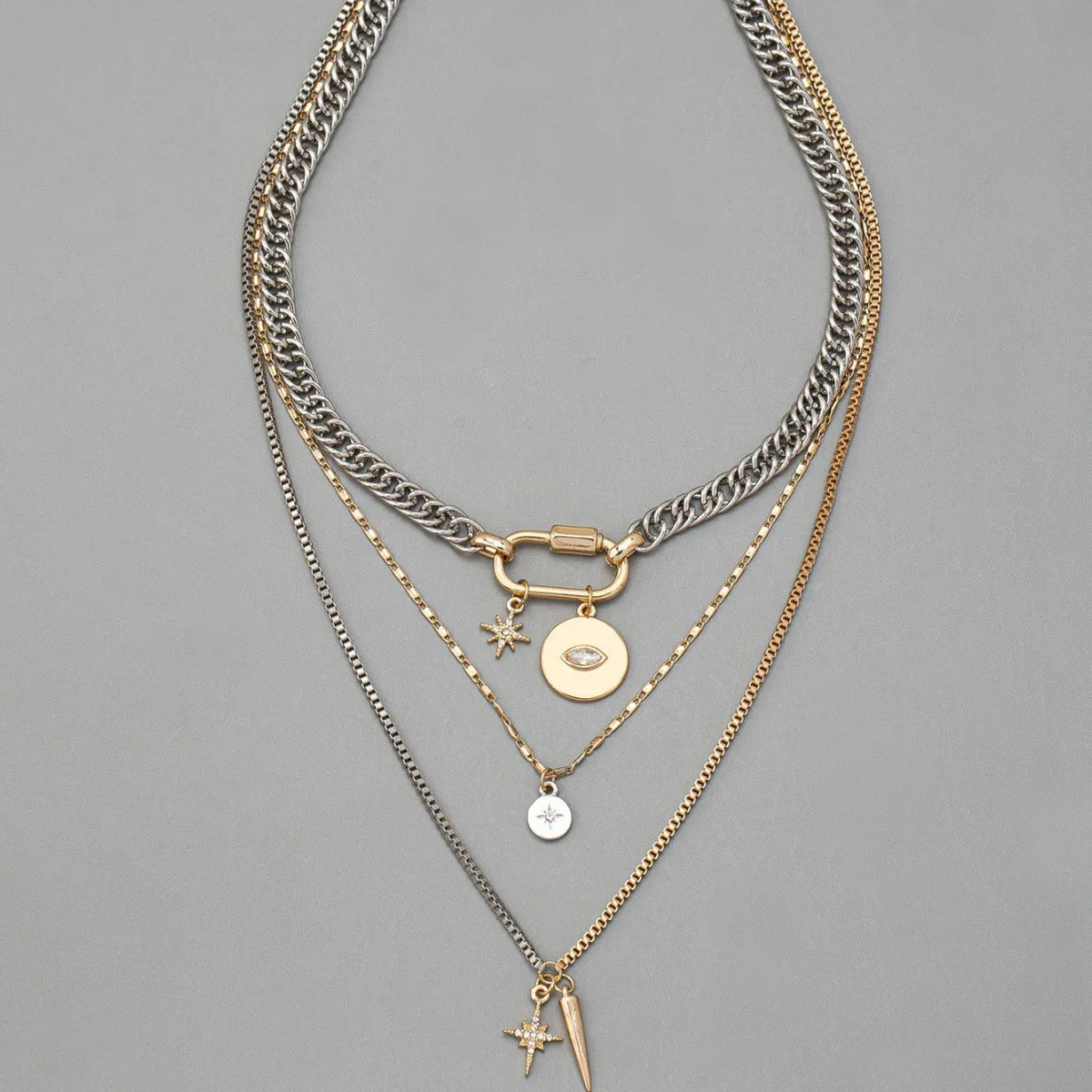 A multilayered gold and silver chain necklace featuring a star eye pendant.