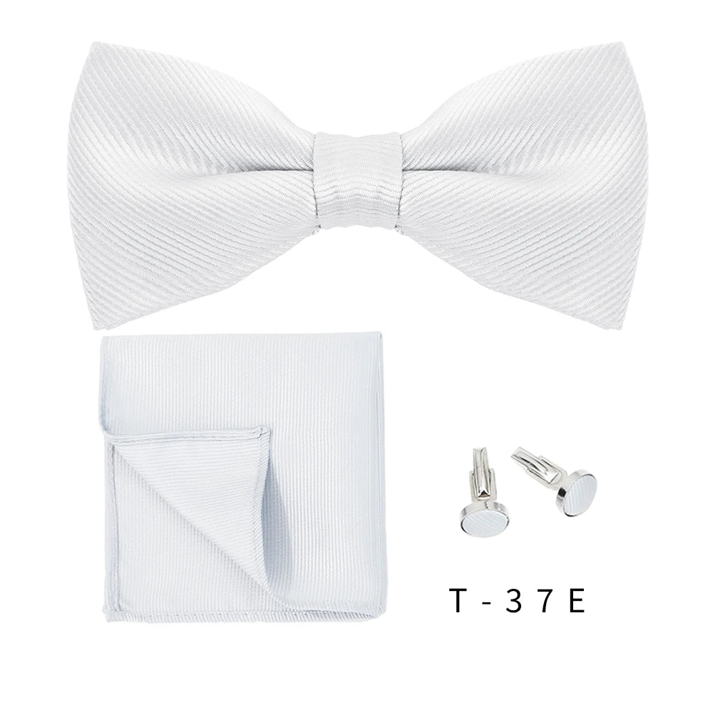 A white bow tie and cufflinks set displayed on a white background.