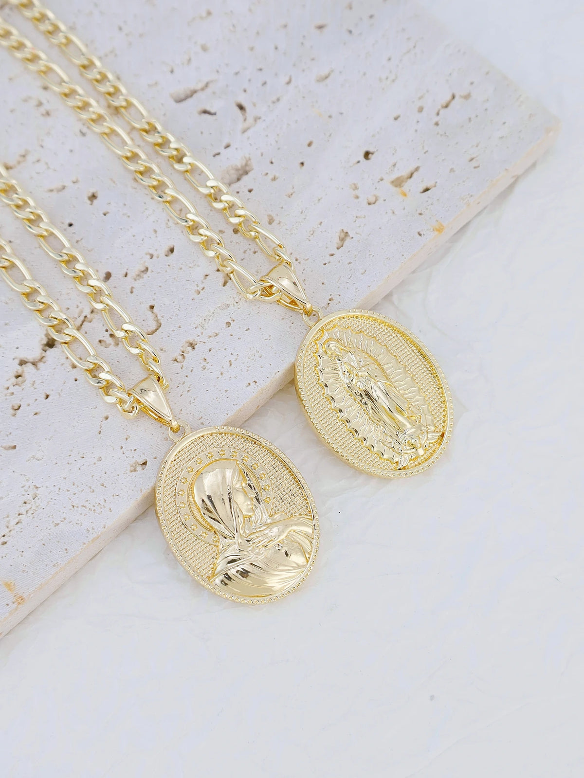 A gold plated pendant necklace featuring a detailed depiction of the Virgin Mary Christ on a gold oval charm.