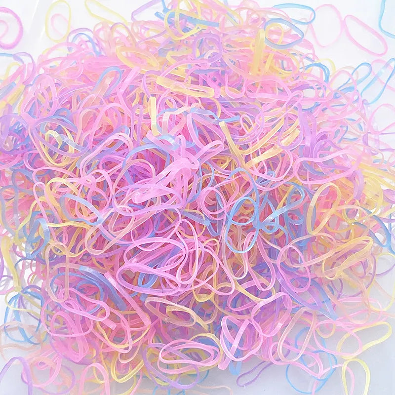 A pile of colorful disposable hair scrunchies in shades of pink, purple, and yellow.