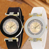 A black quartz wristwatch with a glitter dial and gold accents resting on a light brown surface.