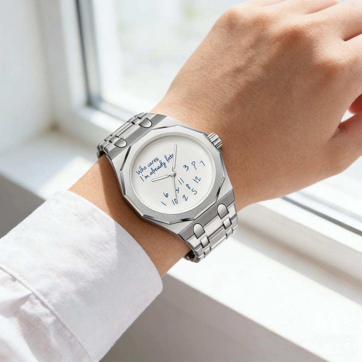 A close-up of a stainless steel watch with a blue dial and the slogan Who cares I'm already late on a person's wrist.