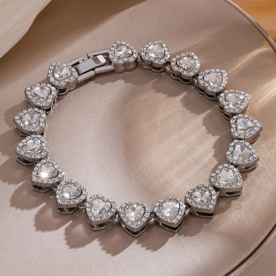 A silver stacking bracelet set featuring multiple heart-shaped clear rhinestones and links.