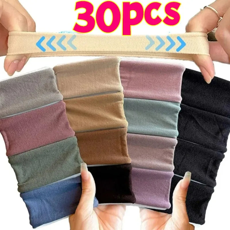 A collection of 30 extra-wide elastic hair bands in various shades of gray, purple, and black held by hands.