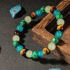 A bracelet made of natural stone beads featuring green and blue agate stones displayed in a wooden box.