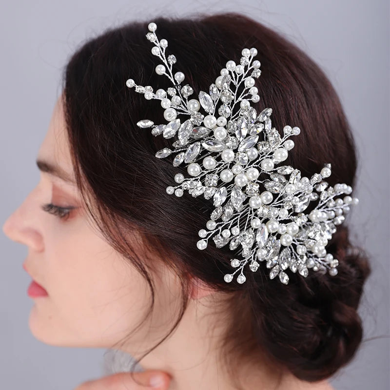 A close-up profile of a woman wearing a bridal headpiece made of sparkling pearl and rhinestone flowers.