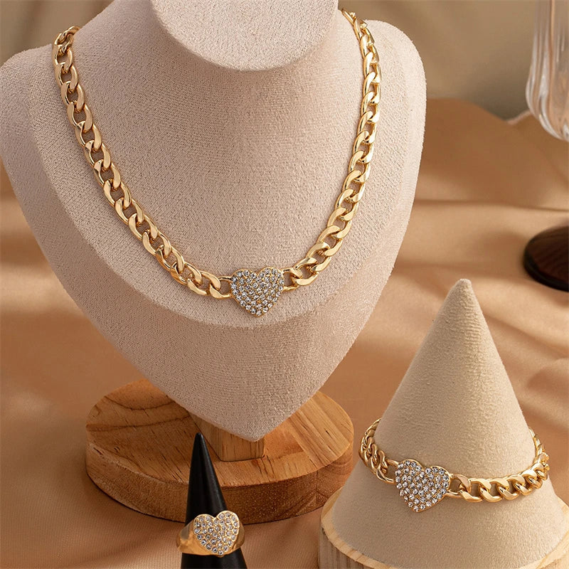 Gold chain necklace with a heart-shaped rhinestone charm displayed on a mannequin.