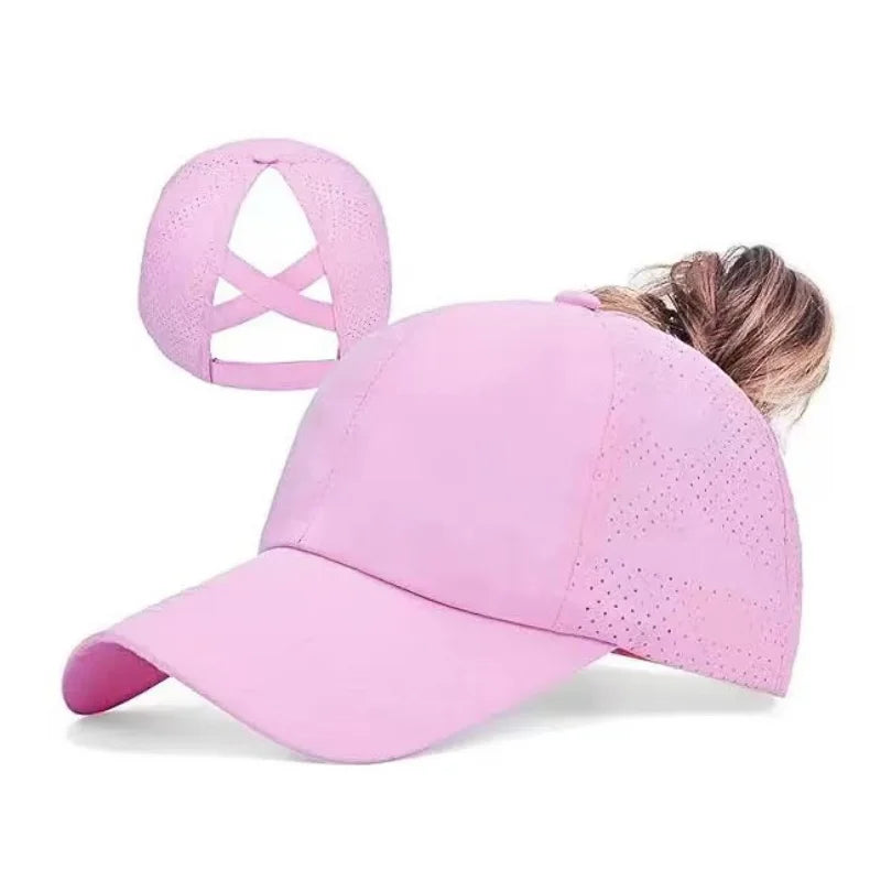 A bright pink breathable mesh criss-cross baseball cap worn by a person.