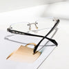 A pair of black retro diamond-edged anti-blue light glasses resting on a white surface next to a light wood object.
