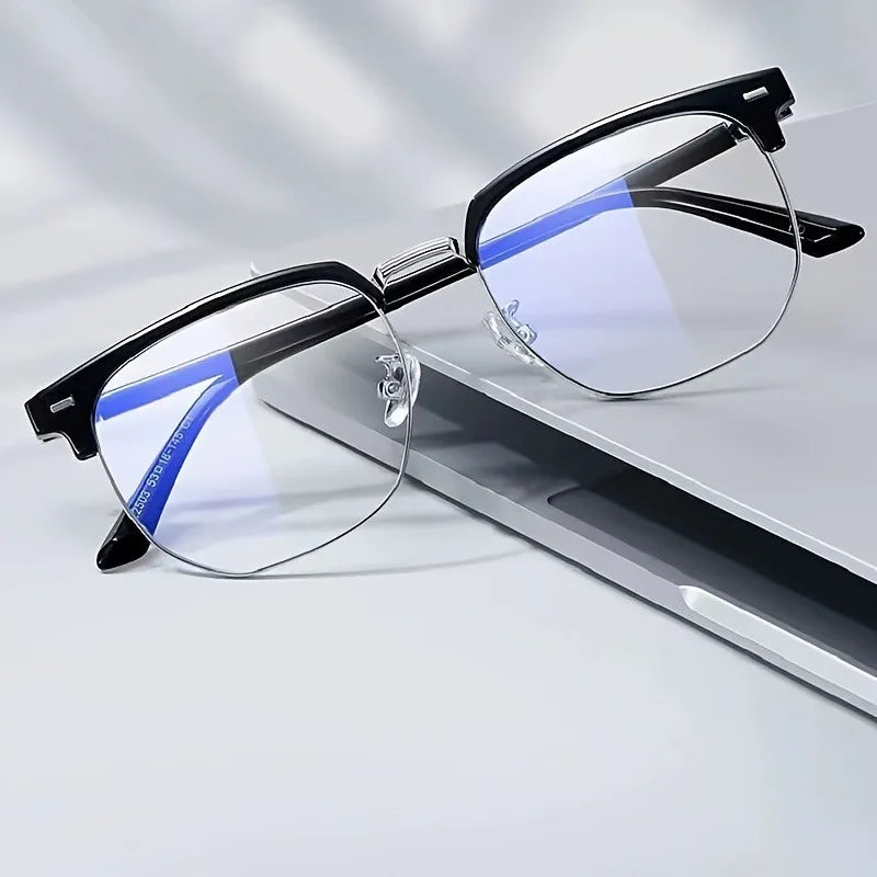 A pair of retro half gold frame anti blue light eyewear with clear lenses resting on a white surface.