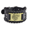 A black leather bracelet featuring a gold-toned etched wolf head design and braided leather detailing.