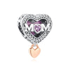 A heart-shaped silver charm featuring a purple gemstone and the letters MOM set in surrounding clear stones.