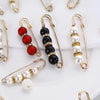 A collection of heavy duty pearl safety pins in gold-toned wire, featuring various colored and sized pearls.