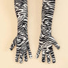 Ein Paar schwarz-weißes Leopardenmuster-Langhandschuhe in Performance-Stil vor hellem Hintergrund.
