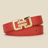 A close-up of a red leather belt with a gold buckle, laid flat on a neutral background.
