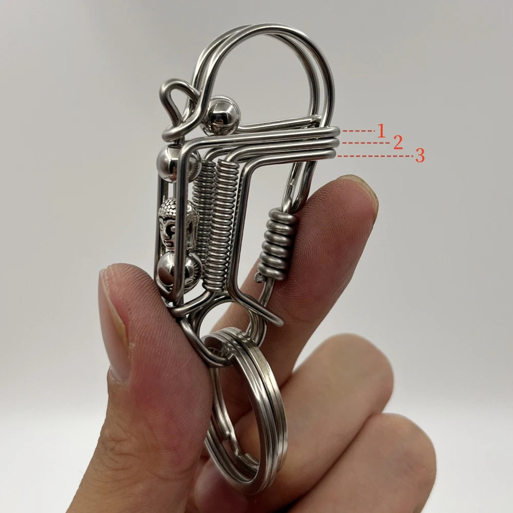 Une main tient un porte-clés mécanique en acier inoxydable avec un ressort et une boucle circulaire.