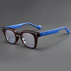 Lunettes de lecture à monture marron avec accents bleus, présentées sur fond gris.