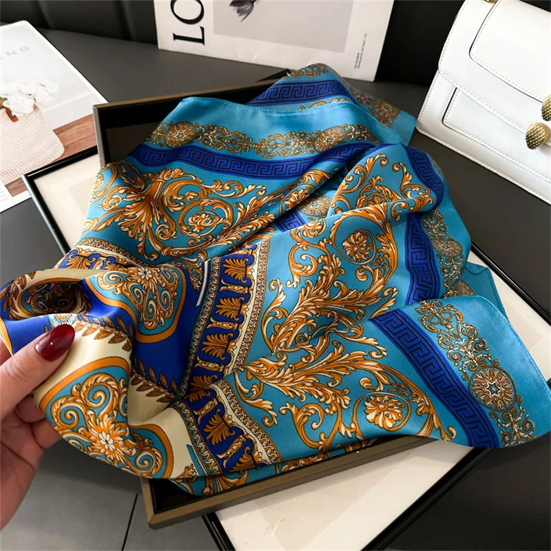 A vibrant blue and gold silk scarf draped on a black tray.