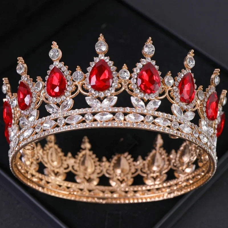 Couronne ton oro avec des gemmes rouges et des cristaux clairs, ressemblant à une tiara de strass baroque.