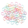 A pile of colorful elastic hair ties in pink, orange, and light blue shades.