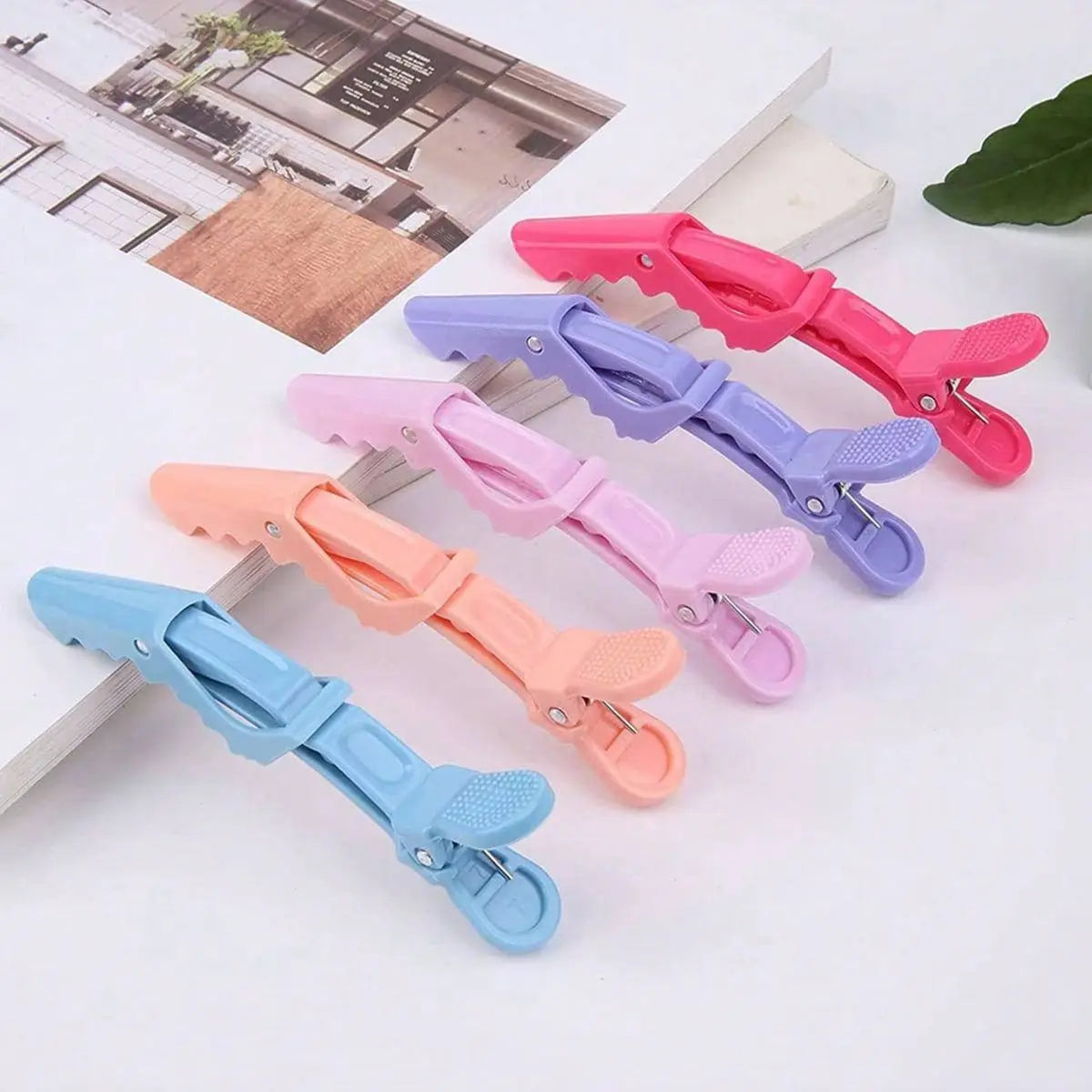 A set of professional multifunctional hair sectioning clips in various shades of pink, purple, and blue.