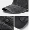 A close-up view of a dark gray washed cotton snapback cap showing the fabric texture and brim.