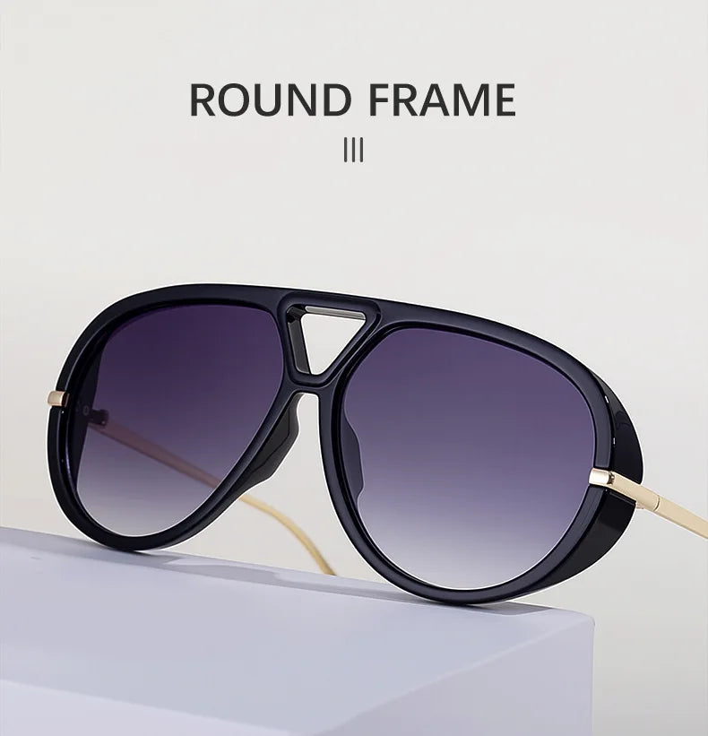 Gafas redondas con marco negro y detalles dorados sobre una superficie blanca.