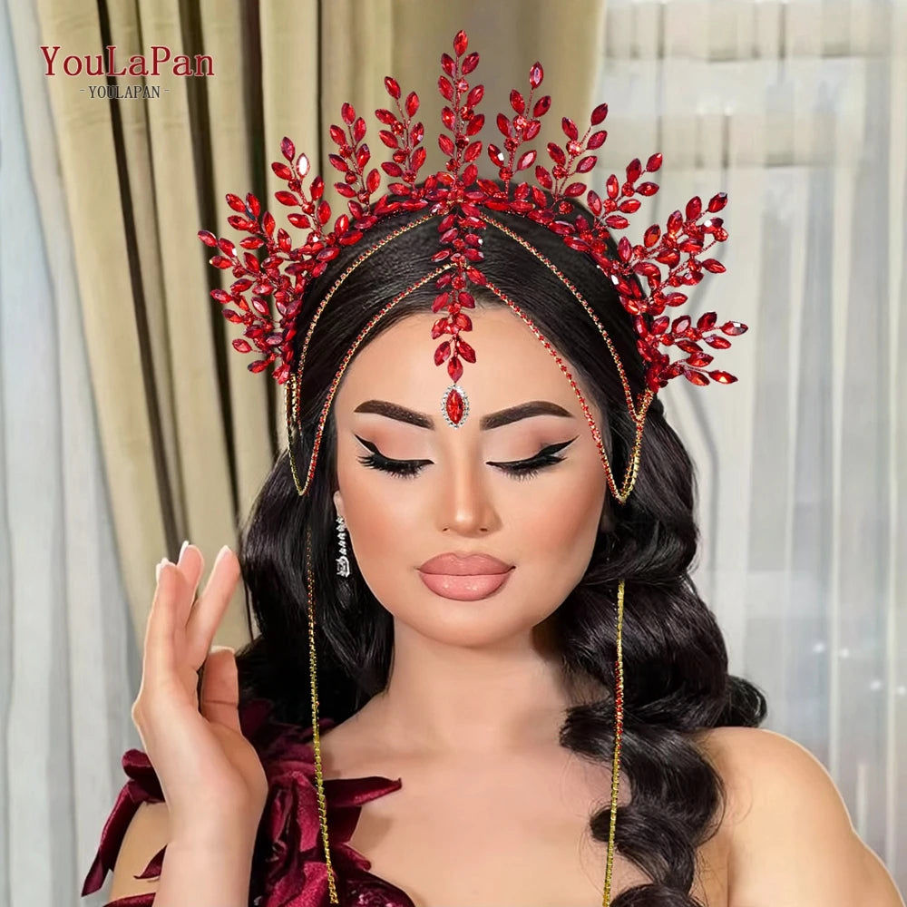 A model wearing a red rhinestone bridal crown headband with gold accents and long dangling chains.