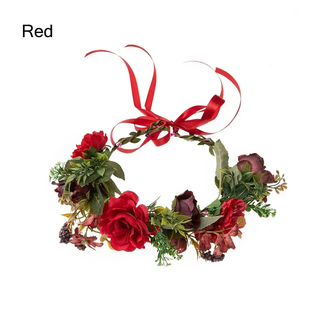 A red bohemian flower headband made of roses and greenery with a satin ribbon.