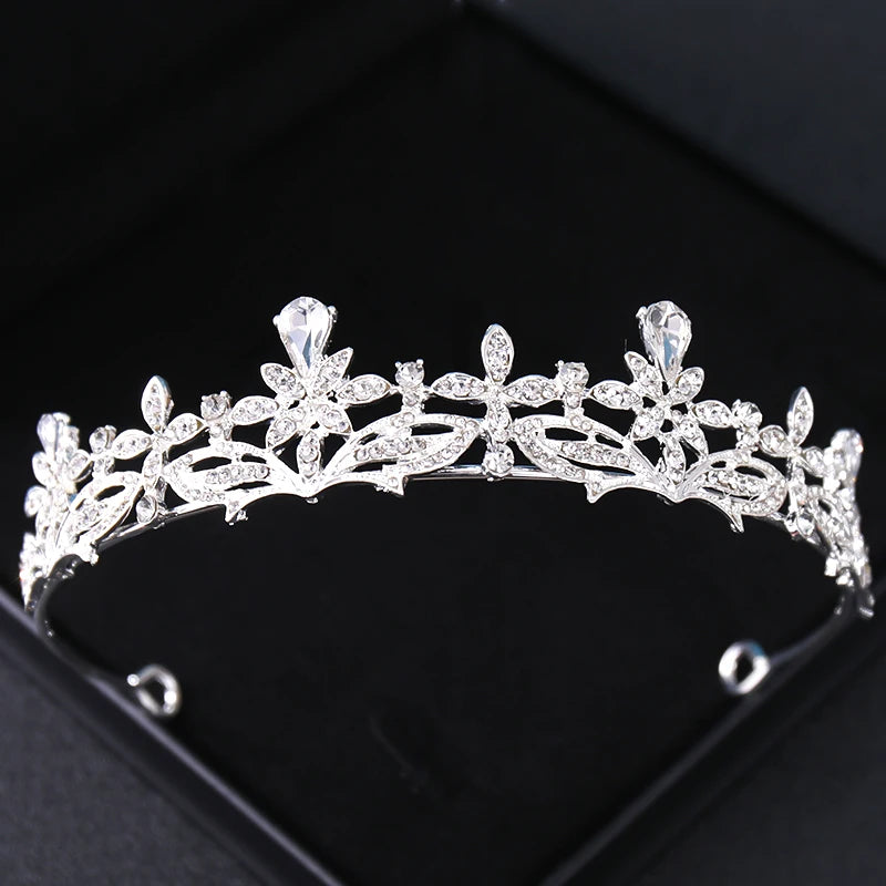 Tiare et couronne en strass de cristal étincelants, accessoire de cheveux, sur une surface sombre.