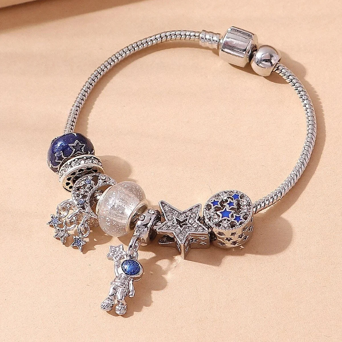 A silver bracelet featuring multiple elements including blue stones, clear beads, and a star charm.