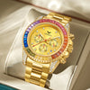 A gold quartz watch with pink and blue accents and diamond pave on the bezel, resting on a light-colored leather surface.