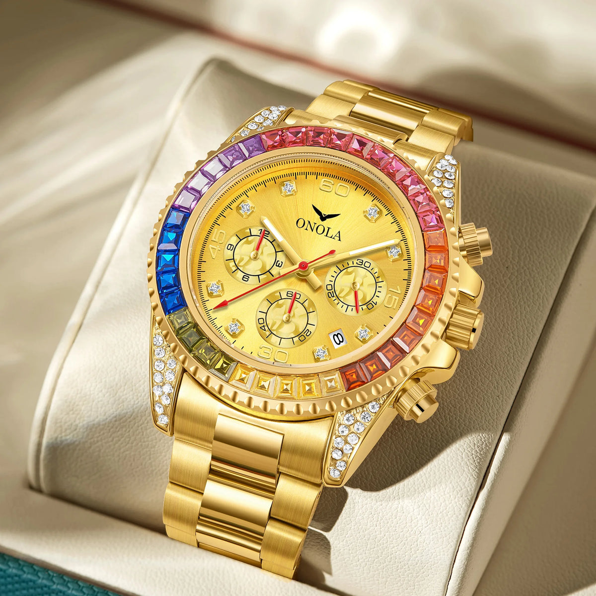 A gold quartz watch with pink and blue accents and diamond pave on the bezel, resting on a light-colored leather surface.