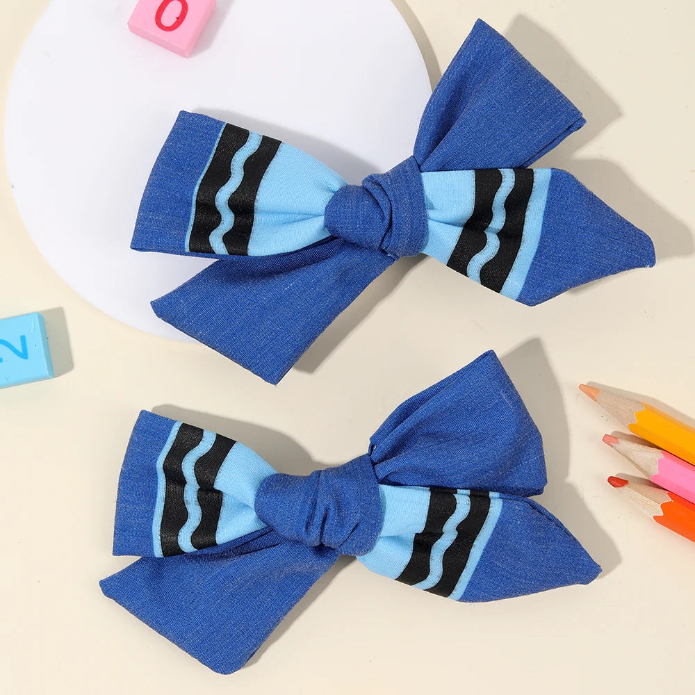 A set of blue and black striped fabric bows used as hair clips.