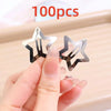 A hand holds several silver star-shaped metal snap clips, demonstrating the size of the hair accessories.