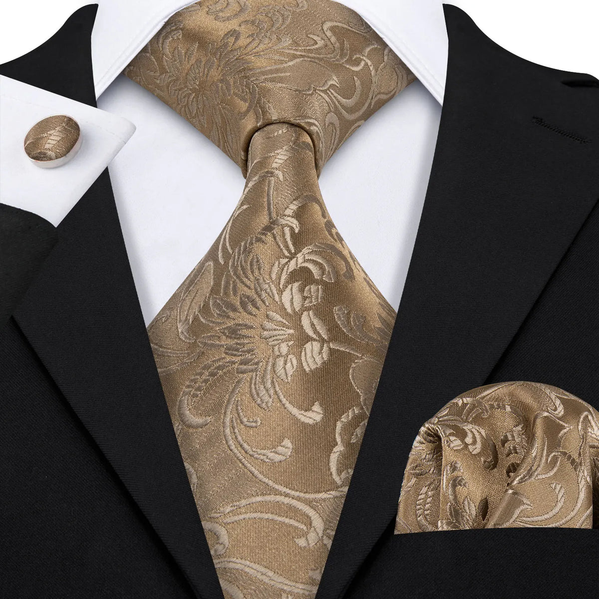 A close-up of a men's silk jacquard tie in gold and beige tones worn with a black suit jacket.