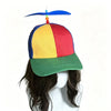 A colorful propeller hat with a rainbow-colored top and green brim is displayed on a person's head.