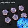 Thirty translucent pink glow-in-the-dark acrylic beads scattered on a dark surface.