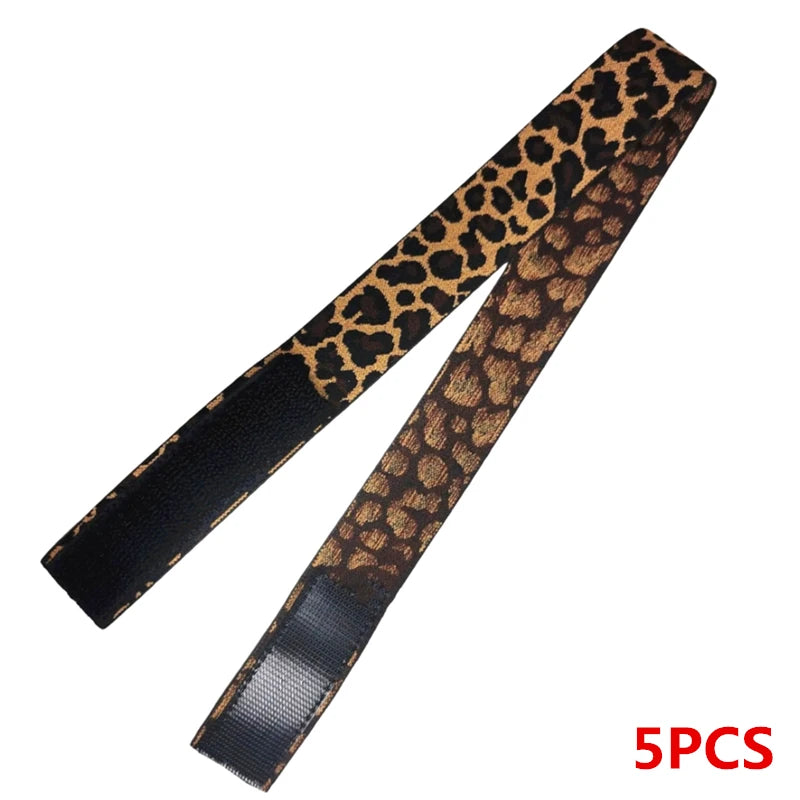 Un set de cinco bandas elásticas de leopardo negro y dorado para bordes de peluca.