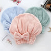 Three fuzzy microfiber hair drying towels in blue, green, and pink are displayed on a white surface.