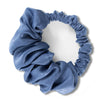 A blue velvet heatless hair curling scrunchie tied in a gathered, ruched style.