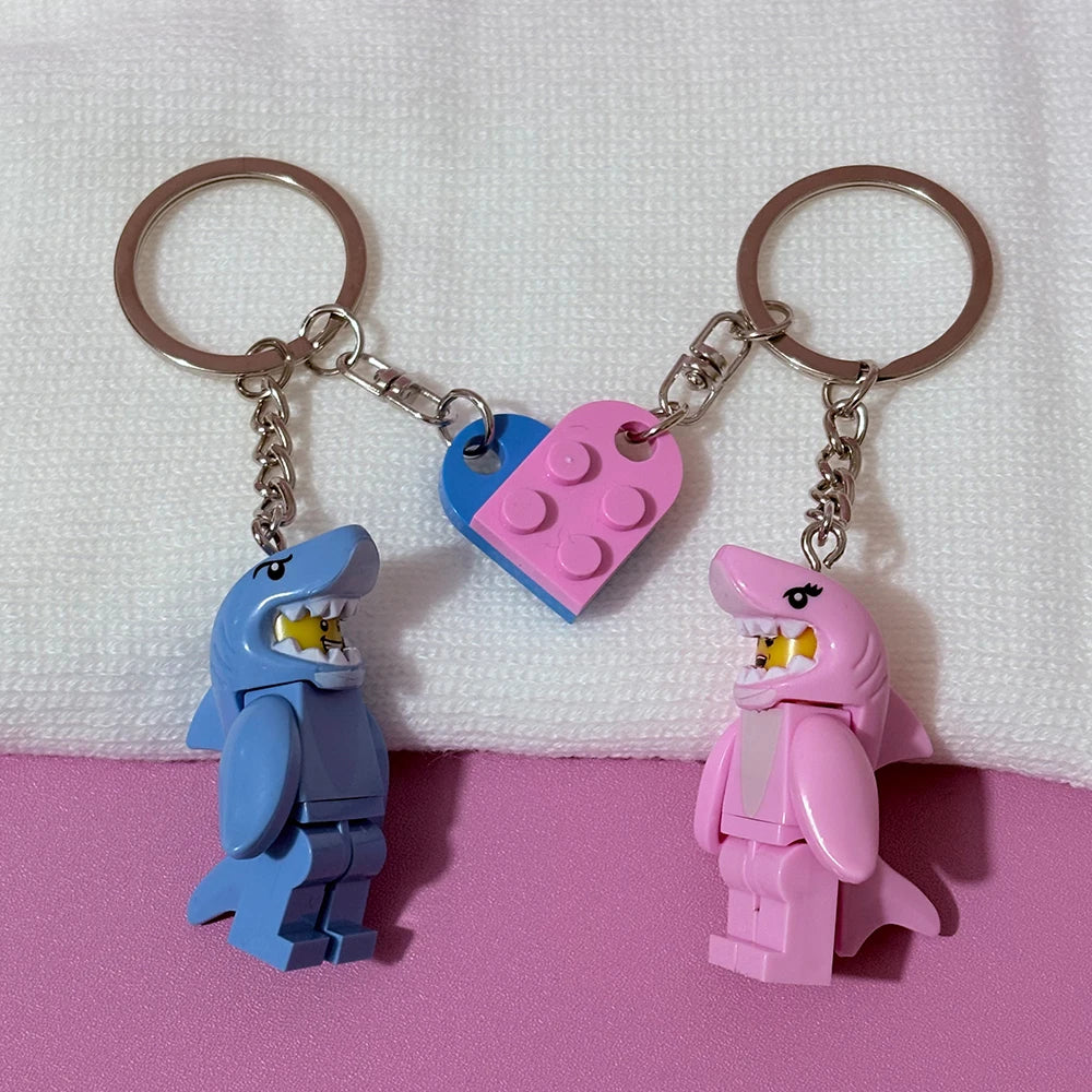 A set of couple shark keychains featuring heart-shaped building blocks in blue and pink.