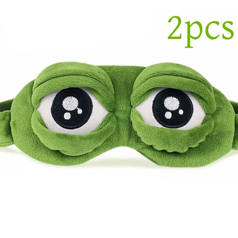 A pair of green frog-themed soft cotton sleep masks with large eyes.