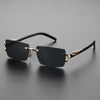 Black rectangular sunglasses with gold accents resting on a dark surface.