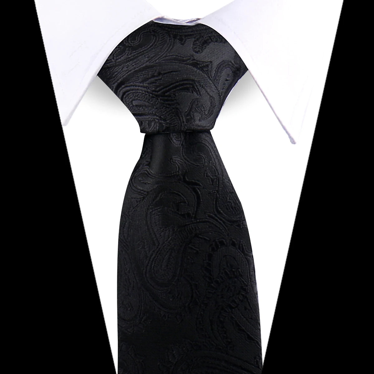 Black silk necktie with an elegant floral paisley pattern worn under a white shirt.